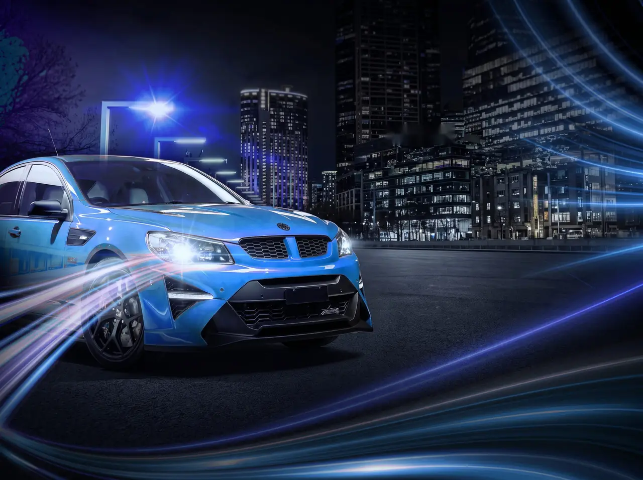 Blue performance sedan at night in a city street